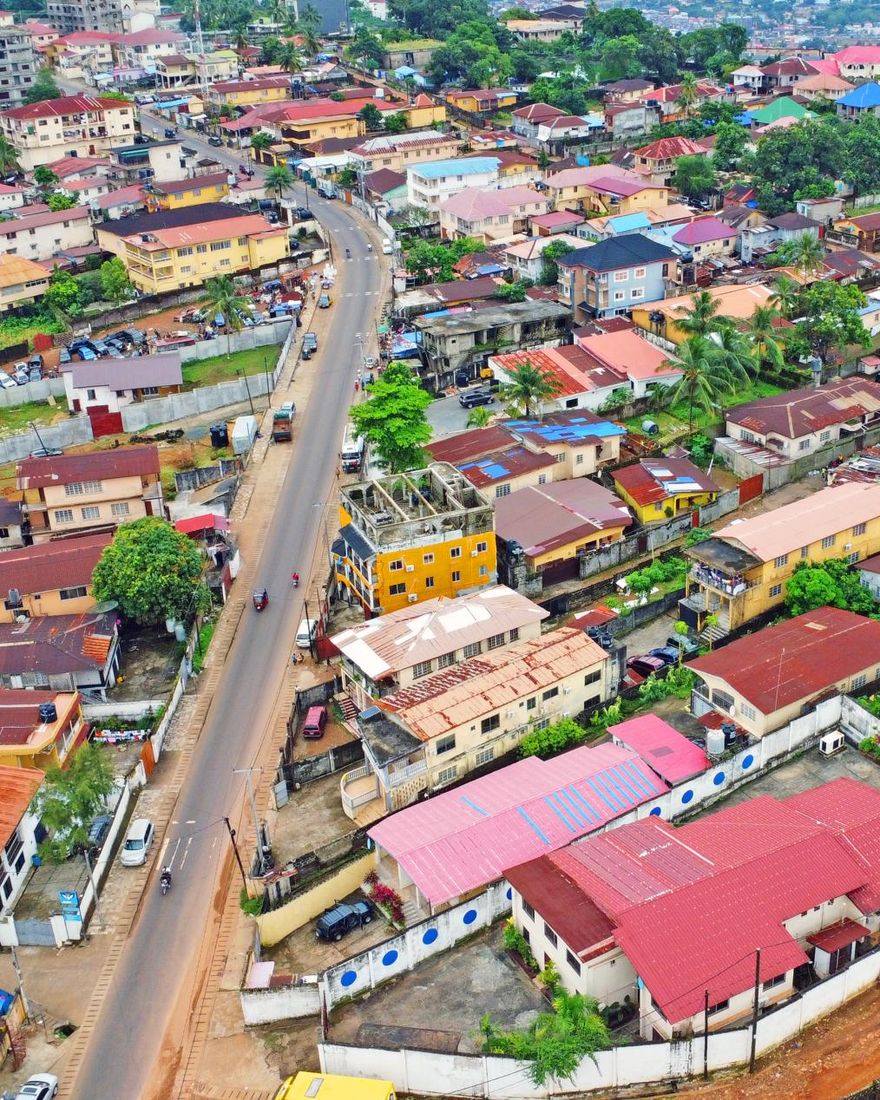 Freetown from the air: colourful roofs along a busy road