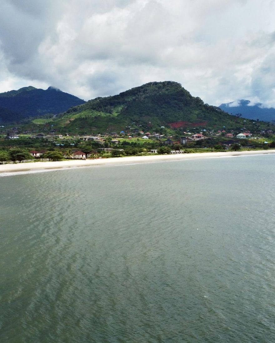 A wide bay below green mountains on the Sierra Leone coast