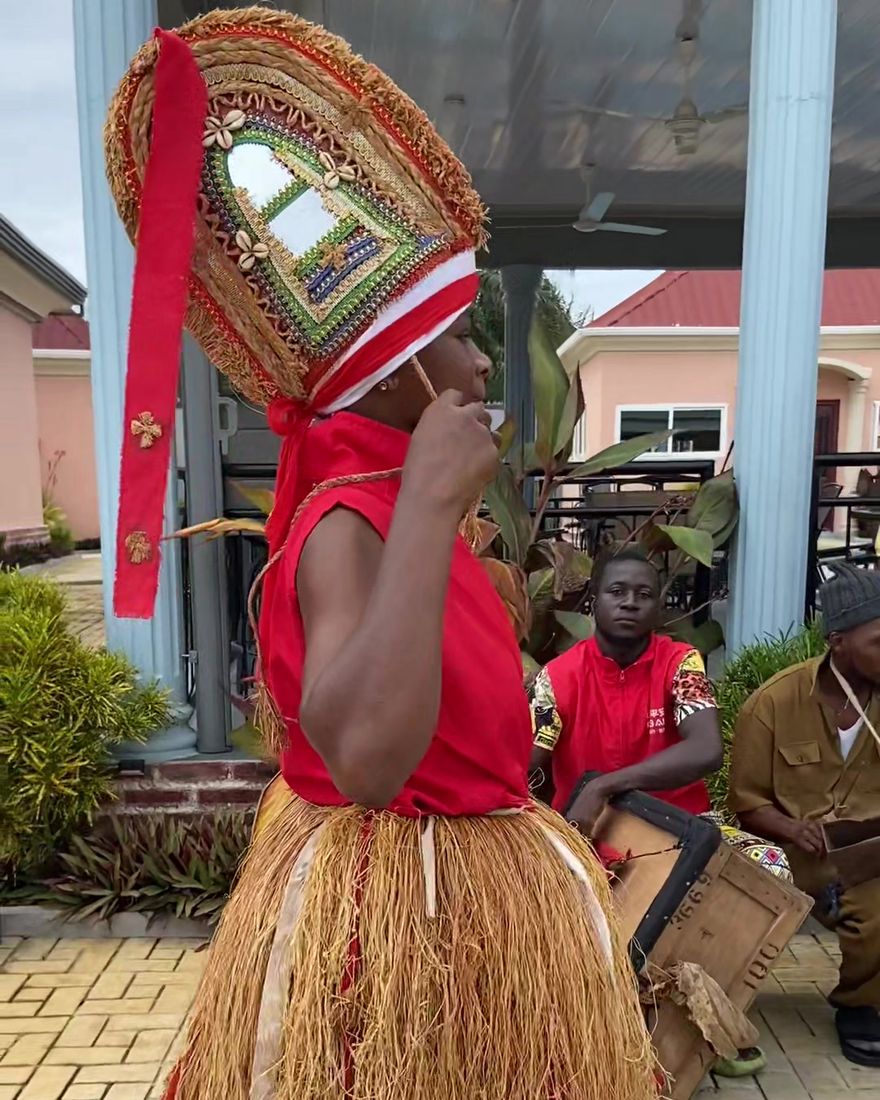 A dancer in a decorated headdress performing with drummers at Africa Waka Waka