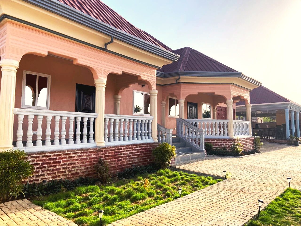 Africa Waka Waka’s guest villas, with white-pillared verandas, red roofs and a paved garden path